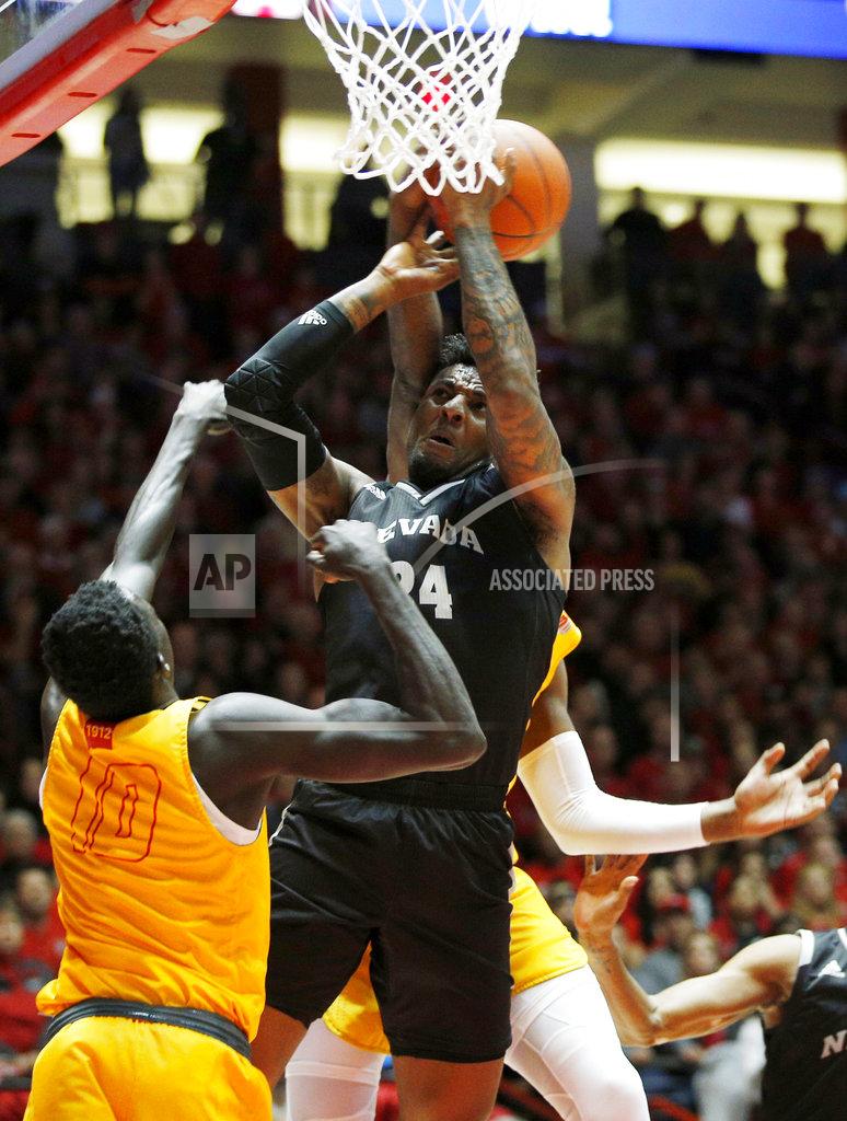 Andres Leighton Nevada forward Jordan Caroline, center, is fouled by New Mexico's Carlton Bragg, obscured, as New Mexico's Makuach Maluach (10), of Australia, looks on during the first half of an NCAA college basketball game in Albuquerque, N.M., Saturday, Jan. 5, 2019. (AP Photo/Andres Leighton)