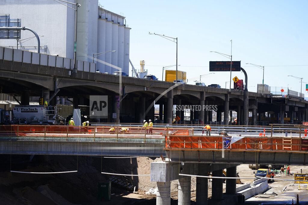 David Zalubowski In this Thursday, April 29, 2021, photograph, workers toil on a bridge over the surface of what will become Interstate 70 north of downtown Denver. The elevated roadway that has served as Interstate 70 will be demolished as part of the 10-mile-long project, which will cost $1.2 billion by completion by winter 2022. (AP Photo/David Zalubowski)