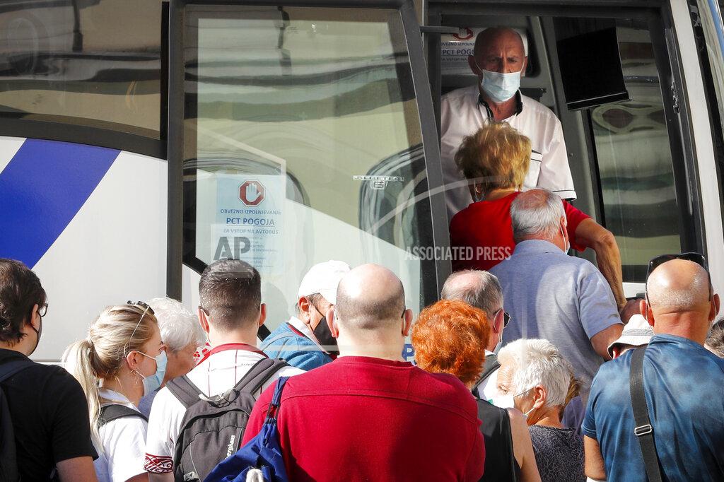Uncredited A bus driver looks at passengers entering a bus in Ljubljana, Wednesday, Sept. 15, 2021. Slovenia has introduced a mandatory anti-COVID vaccination for all civil service employees, further tightening anti-coronavirus measures that have triggered a major riot in the small Alpine state. The measure passed Friday Sept. 17, 2021 says that all state administration employees will need to be vaccinated with one shot by Oct. 1 and by Nov. 1 with the second, unless it's the one-dose Johnson & Johnson vaccine. (AP Photo)