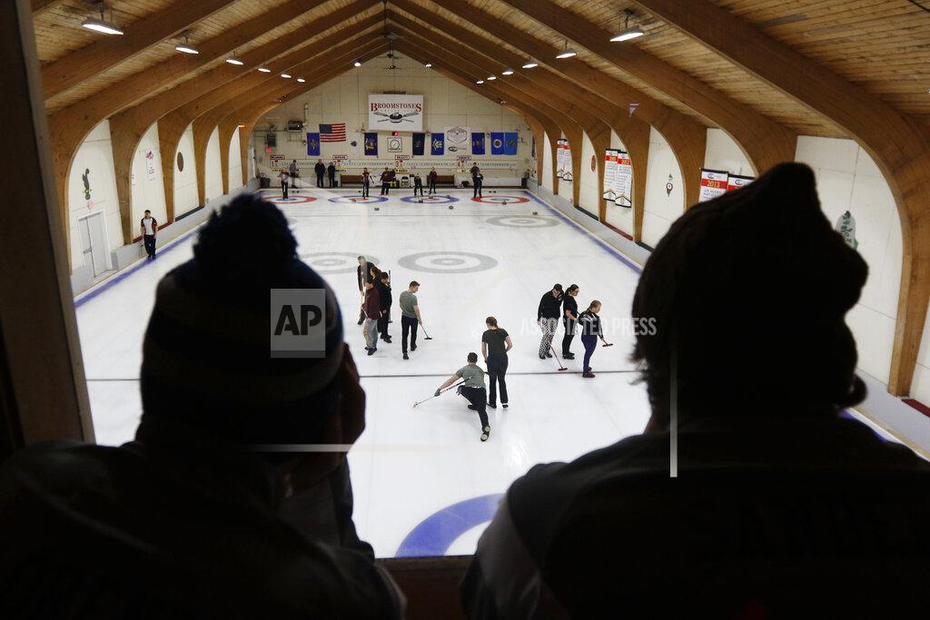 Bill Sikes Members of Syracuse's curling club, foreground, watch matches on the ice below during the college curling national championship, Friday, March 8, 2019, in Wayland, Mass. (AP Photo/Bill Sikes)