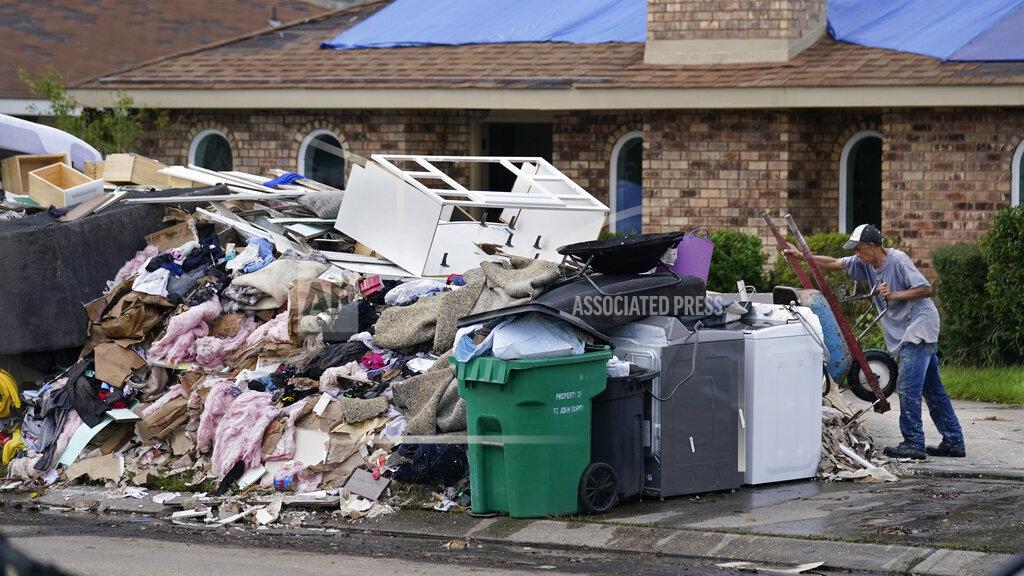 Gerald Herbert A resident dumps debris while gutting his flooded home in the aftermath of Hurricane Ida in LaPlace, La., Tuesday, Sept. 7, 2021. (AP Photo/Gerald Herbert)