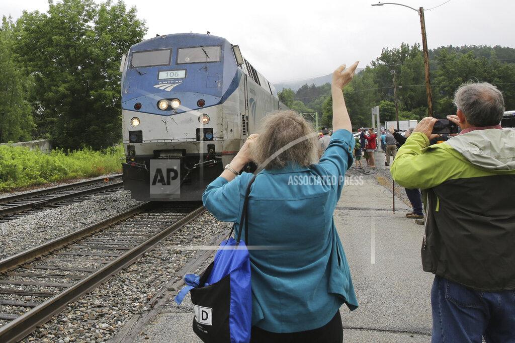 Wilson Ring An onlooker waves as the Amtrak Vermonter passenger train arrives at the Montpelier station, in Berlin, Vt., on Monday July 19, 2021. A celebration was held at Amtrak stations across Vermont to mark the return of the passenger trains to Vermont for the first time since they were suspended at the beginning of the COVID-19 pandemic. (AP Photo/Wilson Ring)