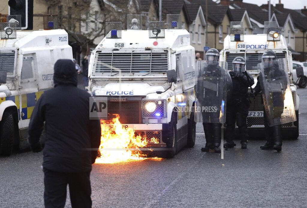 Peter Morrison A Nationalist youth looks at a petrol bomb that was thrown at a police line blocking a road near the Peace Wall in West Belfast, Northern Ireland, Thursday, April 8, 2021. Authorities in Northern Ireland sought to restore calm Thursday after Protestant and Catholic youths in Belfast hurled bricks, fireworks and gasoline bombs at police and each other. It was the worst mayhem in a week of street violence in the region, where Britain's exit from the European Union has unsettled an uneasy political balance. (AP Photo/Peter Morrison)