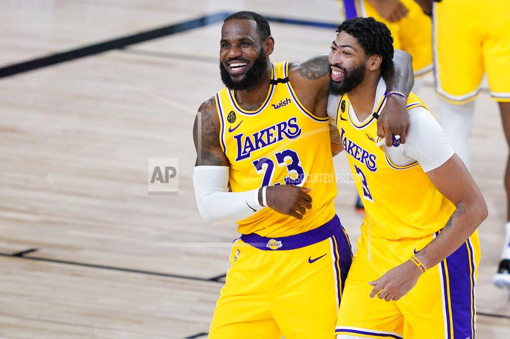 Ashley Landis Los Angeles Lakers' LeBron James (23) and Anthony Davis (3) celebrate after defeating the Denver Nuggets 124-121 during an NBA basketball game Monday, Aug. 10, 2020, in Lake Buena Vista, Fla. (AP Photo/Ashley Landis, Pool)