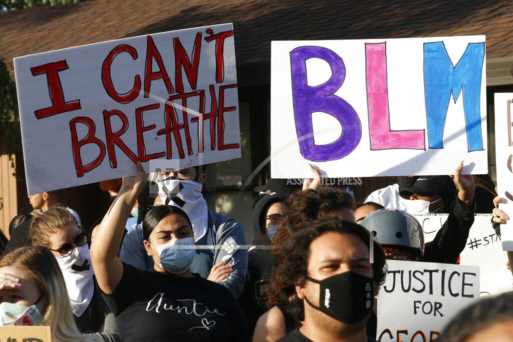 Rich Pedroncelli Protesters hold banners Friday, June 5, 2020, during a demonstration to honor George Floyd, in Sacramento, Calif. Floyd, a black man, died after being restrained by Minneapolis police officers on Memorial Day, May 25, 2020. (AP Photo/Rich Pedroncelli)