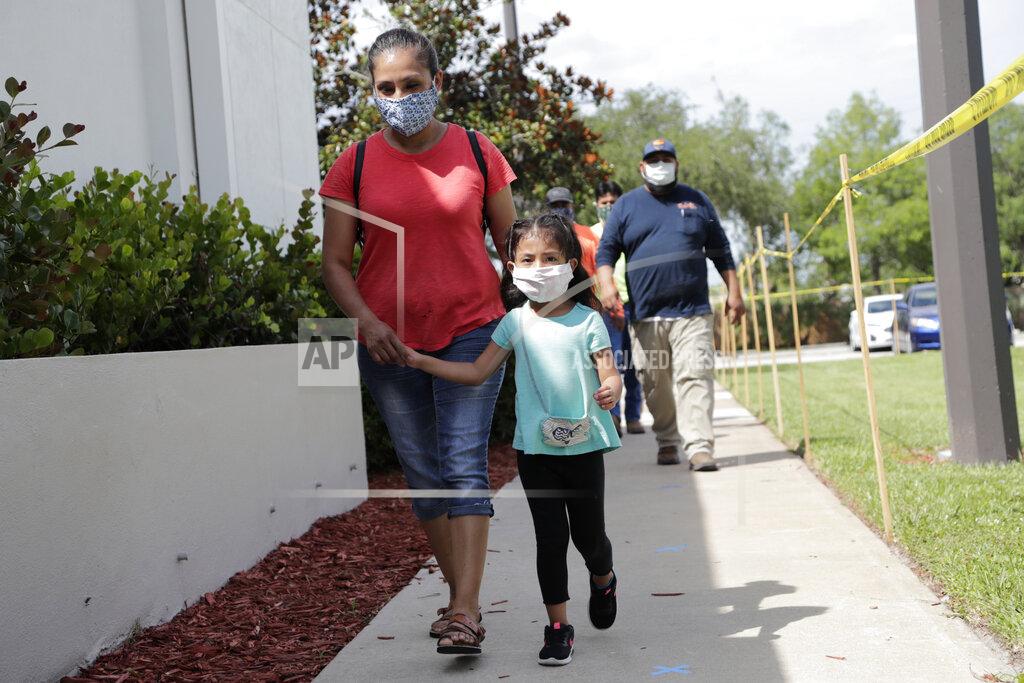 Lynne Sladky In this Monday, June 8, 2020, photo, Flora Garcia arrives with her daughter Krislaya Trejo at the Florida Department of Health in Collier County to be tested for COVID-19 amid the new coronavirus pandemic in Immokalee, Fla. Garcia's husband works as a roofer and tested positive for the virus. Even as the pace of new cases has moderated in the state of Florida, this poor farmworking town in rural Florida is in the throes of an outbreak. (AP Photo/Lynne Sladky)