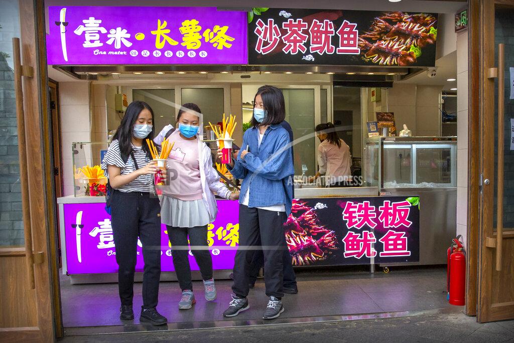 Mark Schiefelbein People wearing face masks to protect against the spread of the new coronavirus buy snacks at a shop on a pedestrian shopping street in Beijing, Saturday, May 16, 2020. According to official data released on Saturday India's confirmed coronavirus cases have surpassed China's. (AP Photo/Mark Schiefelbein)