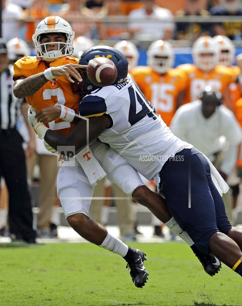 Tennessee's Jarrett Guarantano (2) loses the ball as he is hit by West Virginia's Kenny Bigelow Jr. (40) in the first half of an NCAA college football game in Charlotte, N.C., Saturday, Sept. 1, 2018. The play was ruled an incomplete pass. (AP Photo/Chuck Burton)