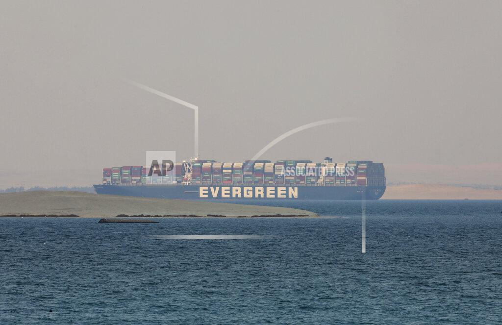 FILE - In this March 30, 2021 file photo, the Ever Given, a Panama-flagged cargo ship, is seen in Egypt's Great Bitter Lake. The Japanese owner of the massive container ship that blocked the Suez Canal for nearly a week, halting billions of dollars in maritime commerce, is asking owners of the freight it is carrying to share the cost of the damages demanded by Egyptian authorities.(AP Photo/Mohamed Elshahed, File)