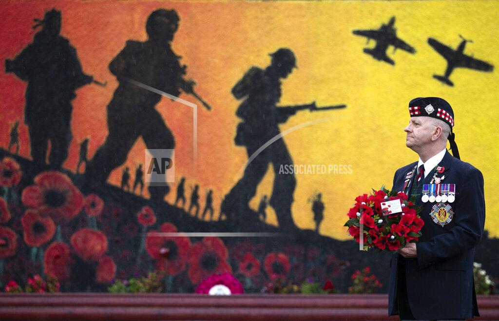 Jane Barlow Veteran Charlie MacVicar, who served for 23 years with Royal Scots (Edinburgh Unit) pays his respects at the Royal British Legion Remembrance Garden, on Remembrance Sunday, in Grangemouth, Scotland, Sunday, Nov. 8, 2020. (Jane Barlow/PA via AP)