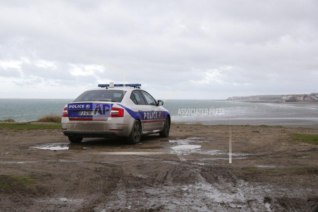 Michel Spingler A police car parks over the shore in Wimereux, northern France, Thursday, Nov. 25, 2021 in Calais, northern France. Children and pregnant women were among at least 27 migrants who died when their small boat sank in an attempted crossing of the English Channel, a French government official said Thursday. French Interior Minister Gerald Darmanin also announced the arrest of a fifth suspected smuggler thought to have been involved in what was the deadliest migration tragedy to date on the dangerous sea lane.(AP Photo/Michel Spingler)