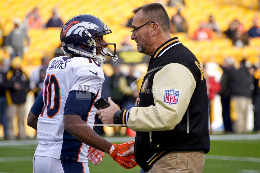 Don Wright FILE - In this Dec. 20, 2015, file photo, Denver Broncos wide receiver Emmanuel Sanders (10) talks with former Pittsburgh Steelers lineman Tunch Ilkin before an NFL football game in Pittsburgh. Ilkin, a Turkis-born two-time Pro Bowl offensive lineman with the Pittsburgh Steelers in the 1980s who went on to become a beloved member of the organization's broadcast team, died on Saturday morning, Sept. 4, 2021, the team said. He was 63. Ilkin, who revealed last fall he was fighting amyotrophic lateral sclerosis (also known as Lou Gehrig's Disease), had been hospitalized recently with pneumonia. (AP Photo/Don Wright, File)