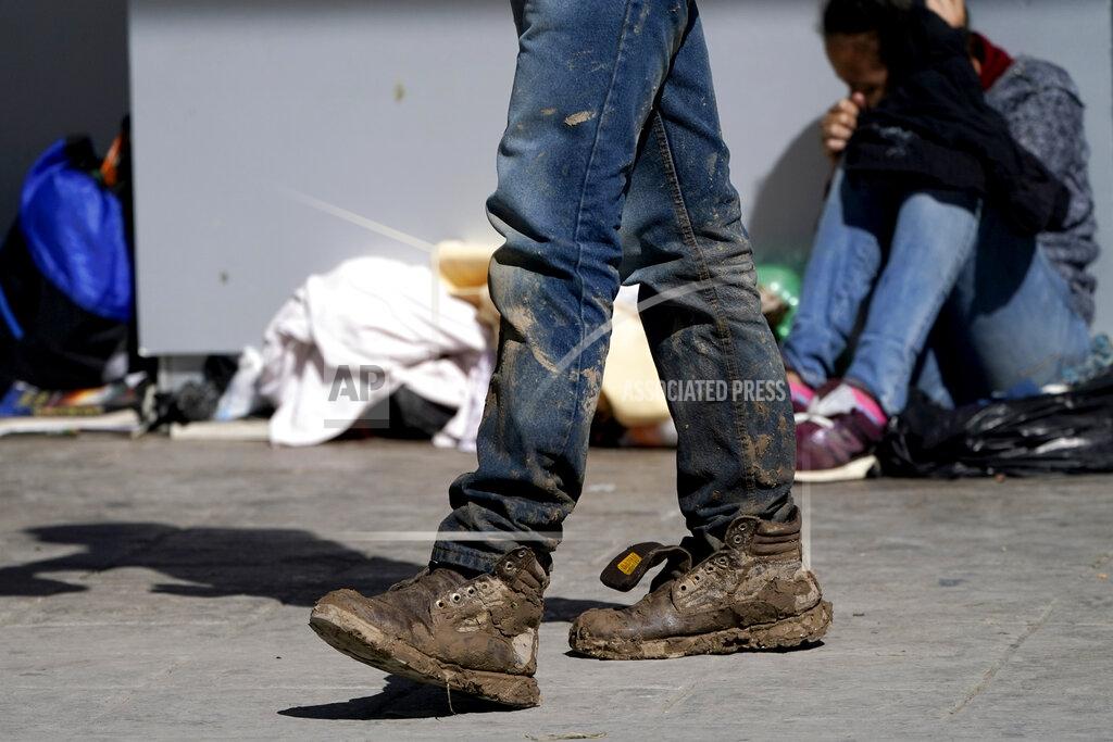 Julio Cortez A migrant's muddy shoes are seen without laces as he walks off the customs checkpoint in Reynosa, Mexico, after being deported by U.S. Customs and Border Protection agents, Thursday, March 18, 2021. Migrants are forced to give up their shoelaces as a security measure after being taken into custody. A surge of migrants on the Southwest border has the Biden administration on the defensive. The head of Homeland Security acknowledged the severity of the problem Tuesday but insisted it's under control and said he won't revive a Trump-era practice of immediately expelling teens and children. (AP Photo/Julio Cortez)
