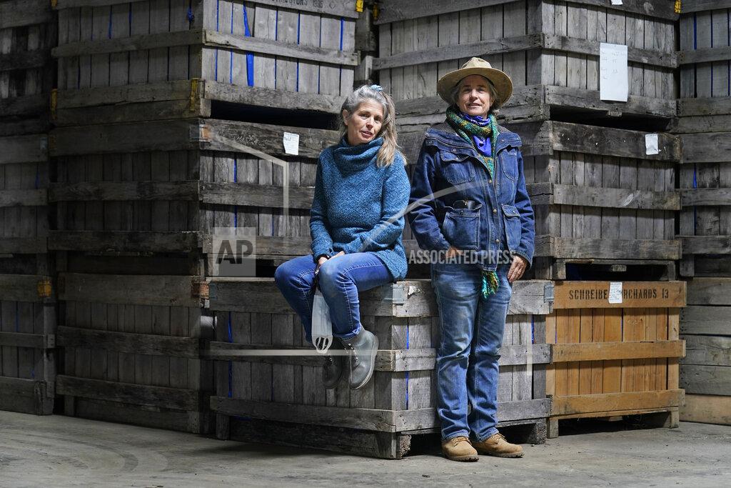 Seth Wenig Gail Hepworth, right, and Amy Hepworth, sisters and co-owners of Hepworth Farms, pose for a picture in front of crates full of hemp plants at Hepworth Farms in Milton, N.Y., Monday, April 12, 2021. Farmers dealing with depressed prices for plants that produce CBD extract are eager to take part in a statewide marijuana market expected to generate billions of dollars a year once retail sales start. They already know how to grow and process cannabis plants, since hemp is essentially the same plant with lower levels of THC, marijuana's active ingredient. Now they're waiting on rules that will allow them to switch seeds. (AP Photo/Seth Wenig)