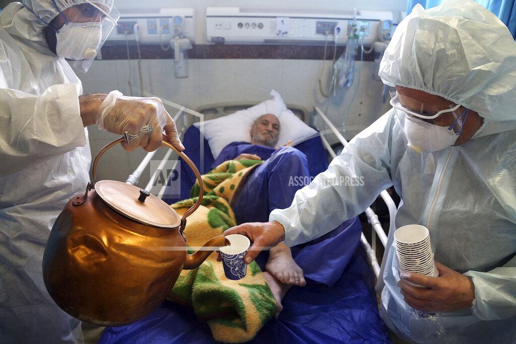 Mohammad Ghadamali Medical workers pour tea for a patient infected with the new coronavirus at a hospital in Tehran, Iran, March 8, 2020. (AP Photo/Mohammad Ghadamali)