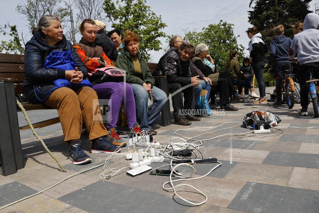 Alexei Alexandrov People charge their phones in Mariupol, in territory under the government of the Donetsk People's Republic, eastern Ukraine, Saturday, May 21, 2022. (AP Photo/Alexei Alexandrov)