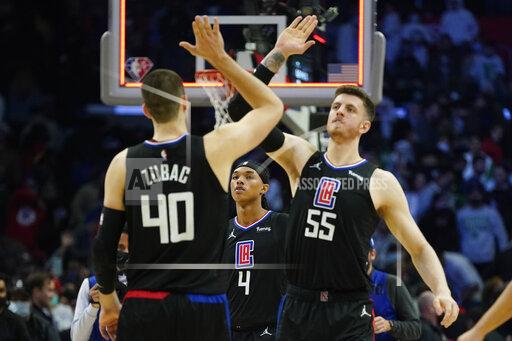 Los Angeles Clippers guard Brandon Boston Jr. (4) watches as center Ivica Zubac (40) and center Isaiah Hartenstein (55) celebrate after a 114-111 win over the Boston Celtics in an NBA basketball game in Los Angeles, Wednesday, Dec. 8, 2021. (AP Photo/Ashley Landis)