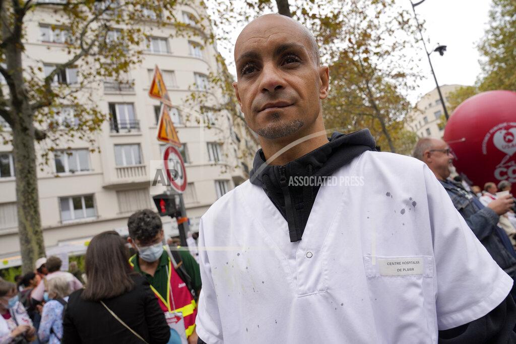 Francois Mori Rachid Ouchem, a medical worker from the Plaisir Hospital, attends a protest gathering outside the Health Ministry in Paris, Tuesday, Sept. 14, 2021 against a law requiring them to get vaccinated by Wednesday or risk suspension from their jobs. The law is aimed at protecting patients from new surges of COVID-19. Most of the French population is vaccinated but a vocal minority are against the vaccine mandate. (AP Photo/Francois Mori)