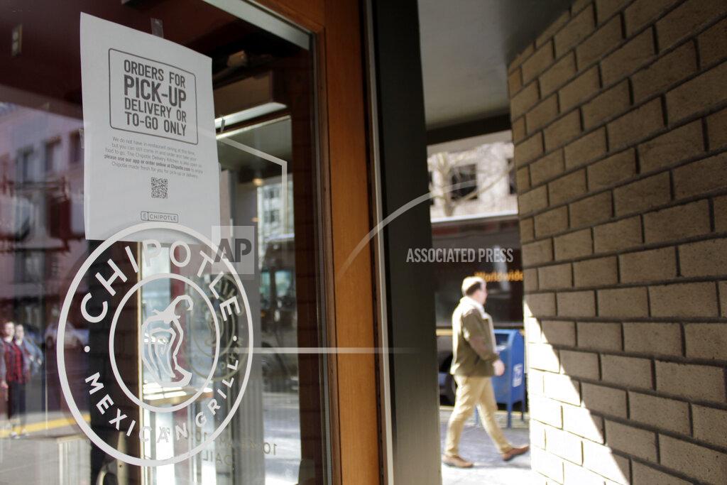 Gillian Flaccus FILE - In this March 16, 2020, file photo, a sign indicating that only carry-out or delivery options are available hangs in the window of a closed Chipotle restaurant in Portland, Ore. U.S. restaurants and stores are rapidly raising pay in an urgent effort to attract more applicants and keep up with a flood of customers as the pandemic eases. McDonald's, Sheetz and Chipotle are just some of the latest companies to follow Amazon, Walmart and Costco in boosting wages, in some cases to $15 an hour or higher. (AP Photo/Gillian Flaccus, File)