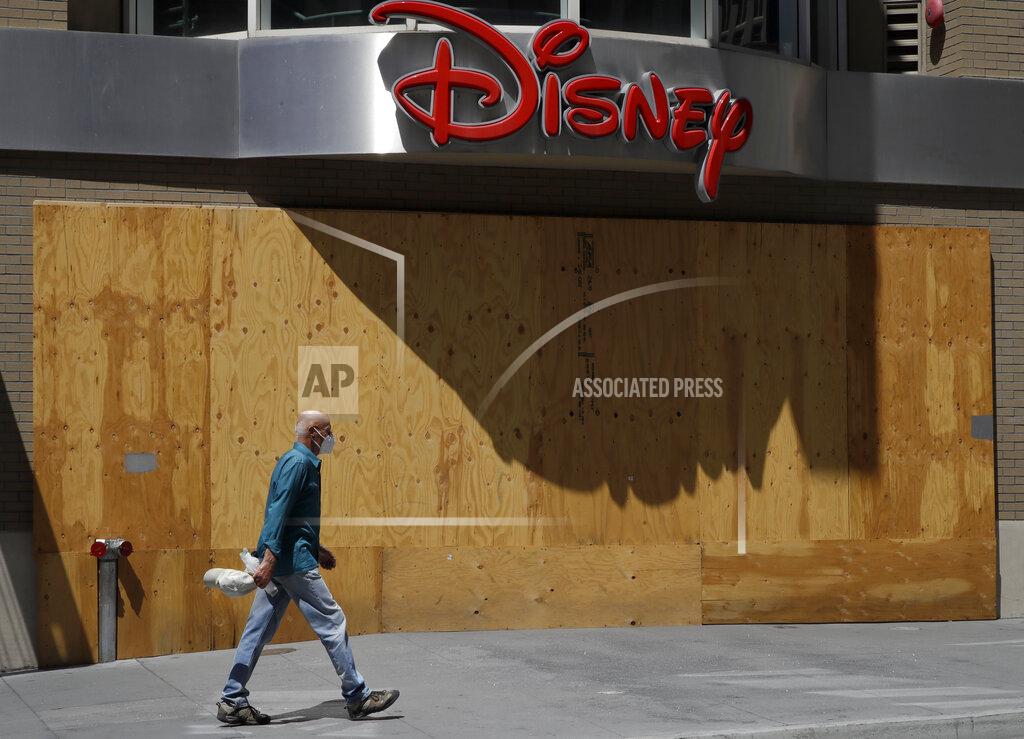 Ben Margot A masked man walks past a boarded up Disney store on Wednesday, May 27, 2020, in San Francisco. While much of California moves swiftly to reopen things like hair salons under California Gov. Gavin Newsom's guidance, the San Francisco Bay Area is continuing to keep the brakes on. Some health officials are questioning whether the state is taking enough time to assess the effects of reopening things like stores before jumping ahead to broader re-openings, risking a surge in infections. (AP Photo/Ben Margot)