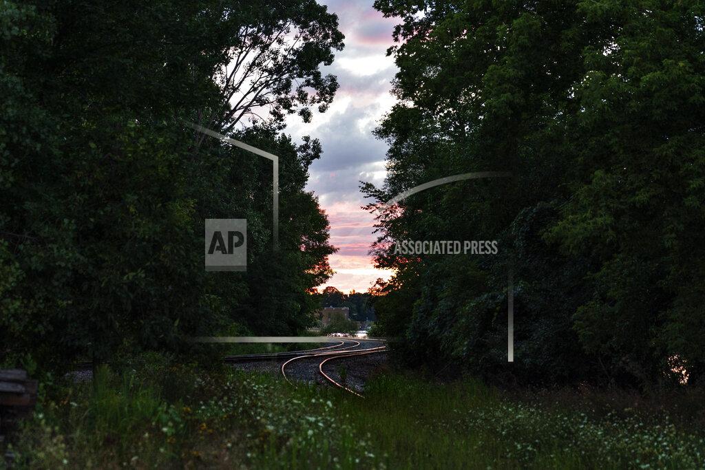 David Goldman Railroad tracks weave through trees along the Fox River leading to the Midwest Paper Group mill in Little Chute, Wis., part of the greater Appleton area, Aug. 17, 2020. The currents of the Fox River power the smoke-stacked paper mills that built fortunes. Steamboats and trains brought the trappings of Victorian-era comfort. The end of World War II brought a suburban buildout and teenagers increasingly left dairy farms for union jobs at mills and foundries. (AP Photo/David Goldman)