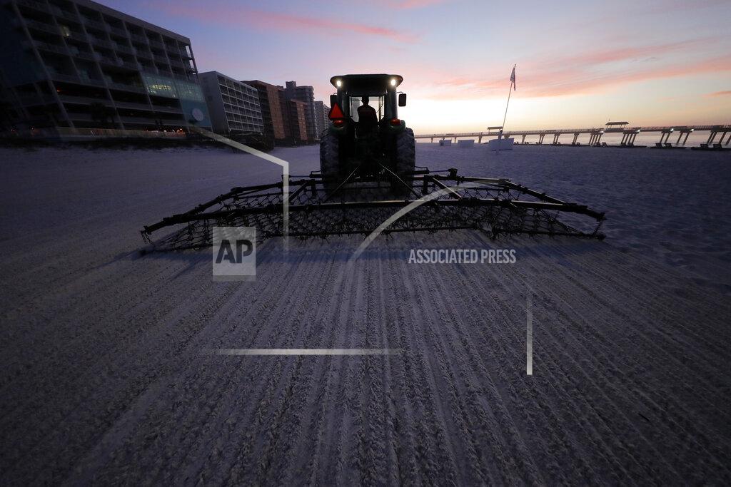 Gerald Herbert In this March 13, 2020, photo, beach cleaners, that were funded with money from BP due to the Deepwater Horizon oil spill, operate at dawn in Orange Beach, Ala. As oil spewed into the Gulf of Mexico from a blown-out BP well in 2010, residents wondered whether their home would ever be the same. The Deepwater Horizon disaster changed the region, with a flood of spending altering landscapes and attitudes. (AP Photo/Gerald Herbert)