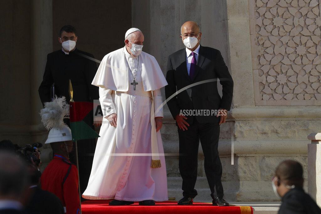 Andrew Medichini Pope Francis is welcomed by Iraqi President Barham Salih, at Baghdad's Presidential Palace, Iraq, Friday, March 5, 2021. Pope Francis has arrived in Iraq to urge the country's dwindling number of Christians to stay put and help rebuild the country after years of war and persecution, brushing aside the coronavirus pandemic and security concerns. (AP Photo/Andrew Medichini)