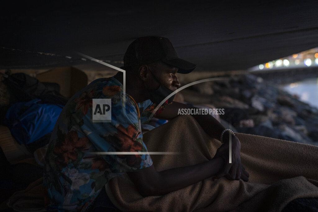 Emilio Morenatti Khalid, a migrant from Gambia, sits on a breakwater under a bridge in Gran Canaria island, Spain, on Saturday, Aug. 22, 2020. More than 250 people are known to have died or gone missing in the Atlantic route so far this year according to the International Organization for Migration. That's already more than the number of people who perished trying to cross the Western Mediterranean in all of last year. (AP Photo/Emilio Morenatti)