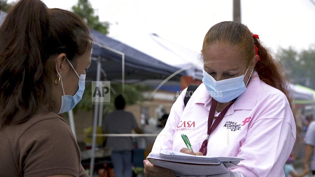 Federica Narancio A "promotora" (health promoter) from CASA, a Hispanic advocacy group, tries to enroll Latinos as volunteers to test a potential COVID-19 vaccine, at a farmers market in Takoma Park, Maryland on Sept. 9, 2020. Minority enrollment in studies of two shots has inched up in recent weeks, but even more is needed this fall as additional vaccine testing gets underway over the next two months. (AP Photo/Federica Narancio)
