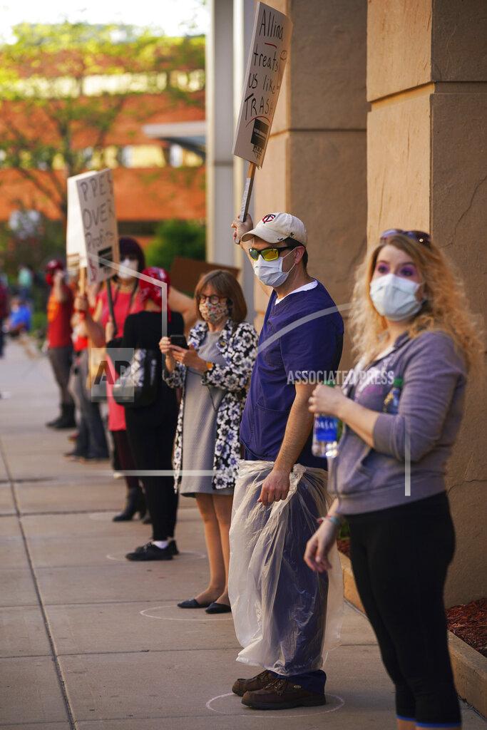 Jeff Wheeler Leif Thorsgaard, an ER nurse at United Hospital, wears a trash bag like he says he wears during his shift to protect his scrubs, Wednesday, May 20, 2020, in St. Paul, Minn., during an informational picket sponsored by the Minnesota Nurses Association along Smith Avenue, outside United Hospital. Nurses are asking for a say in worker protections, increased PPE resources with higher safety standards and an end to retaliation against workers who have tried to protect themselves from the COVID-19 virus. After picketing, they marched to the State Capitol to hear speakers. (Jeff Wheeler/Star Tribune via AP)