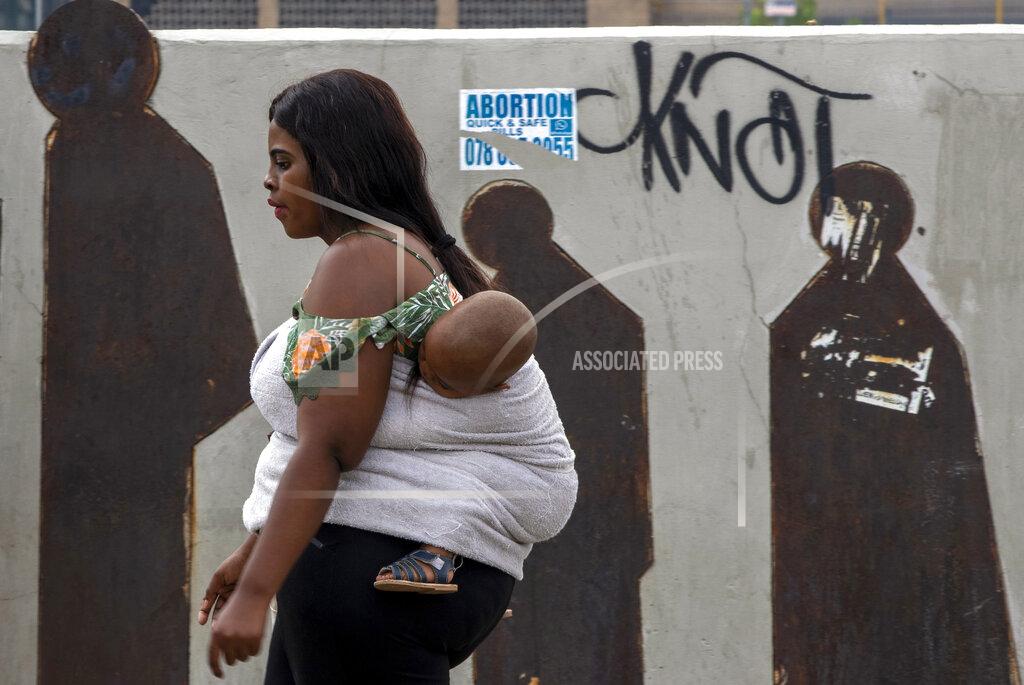 People walk along a downtown street in Johannesburg, South Africa, Monday, March 16, 2020. Millions of women and girls globally have lost access to contraceptives, abortion services and related care because of the coronavirus pandemic. Now the first widespread measure of the toll says India with its abrupt, months-long lockdown has been hit especially hard. (AP Photo/Themba Hadebe)