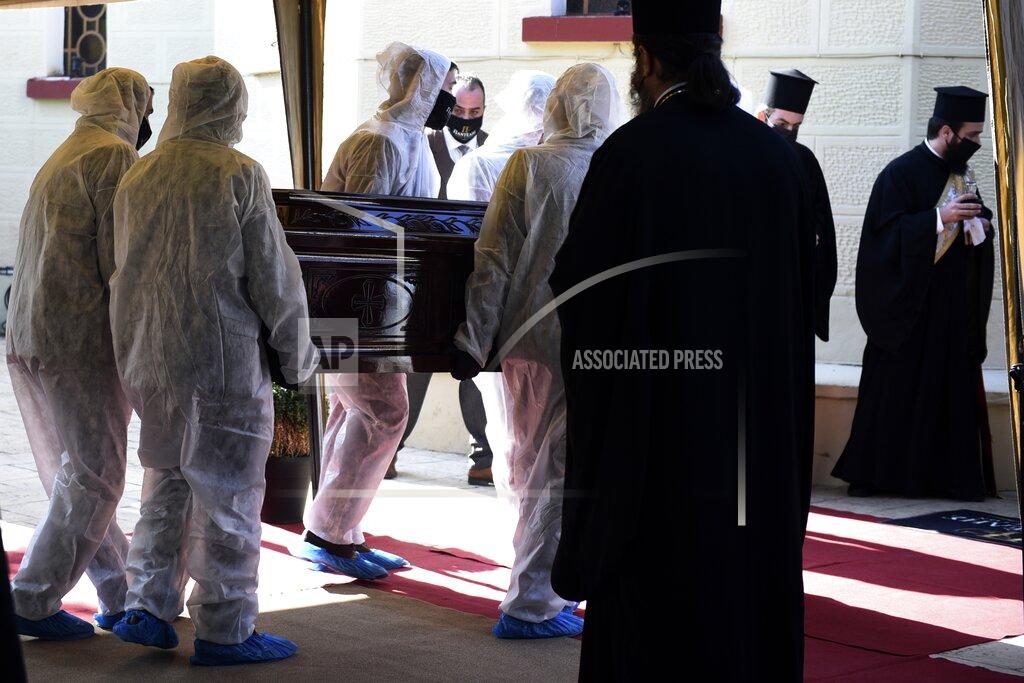 Giannis Papanikos Priests wearing face masks to protect against the spread of the coronavirus, attend the funeral of senior clergyman Ioannis of Lagadas after he died of COVID-19, in Greece's Orthodox Church, in the northern city of Thessaloniki, Greece, Monday, Nov. 16, 2020. Metropolitan Bishop Ioannis of Lagadas, 62, was an outspoken advocate of maintaining communion ceremonies _ at which worshipers are given bread as well as wine with a shared spoon _ during the pandemic, arguing that there was no risk of transmission. (AP Photo/Giannis Papanikos)