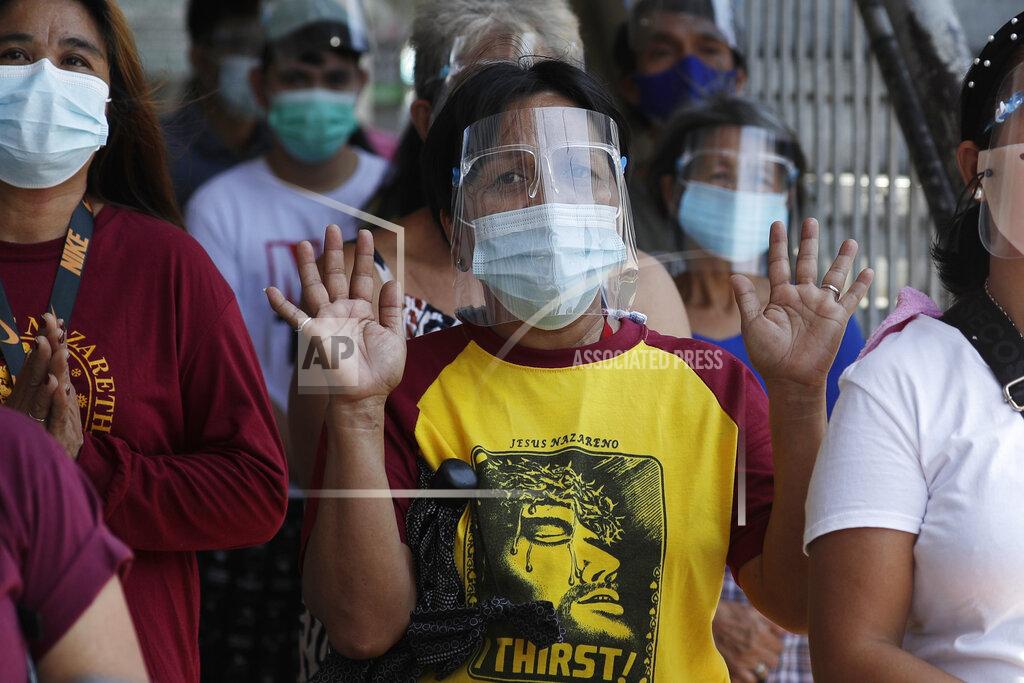 Aaron Favila A devotee offers prayers outside the Quiapo church on Good Friday, April 2, 2021 as the government implements a strict lockdown to prevent the spread of the coronavirus in Manila, Philippines. Filipinos marked Jesus Christ's crucifixion Friday in one of the most solemn holidays in Asia's largest Catholic nation which combined with a weeklong coronavirus lockdown to empty Manila's streets of crowds and heavy traffic jams. Major highways and roads were eerily quiet on Good Friday and churches were deserted too after religious gatherings were prohibited in metropolitan Manila and four outlying provinces. (AP Photo/Aaron Favila)