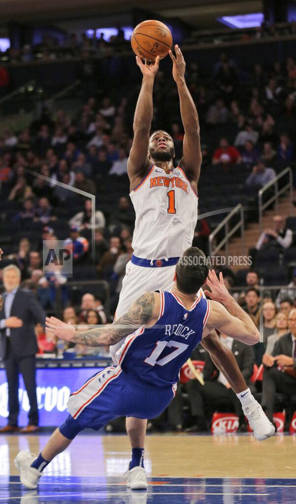 Seth Wenig Philadelphia 76ers' JJ Redick, bottom, falls as New York Knicks' Emmanuel Mudiay shoots during the second half of the NBA basketball game, Sunday, Jan. 13, 2019, in New York. (AP Photo/Seth Wenig)