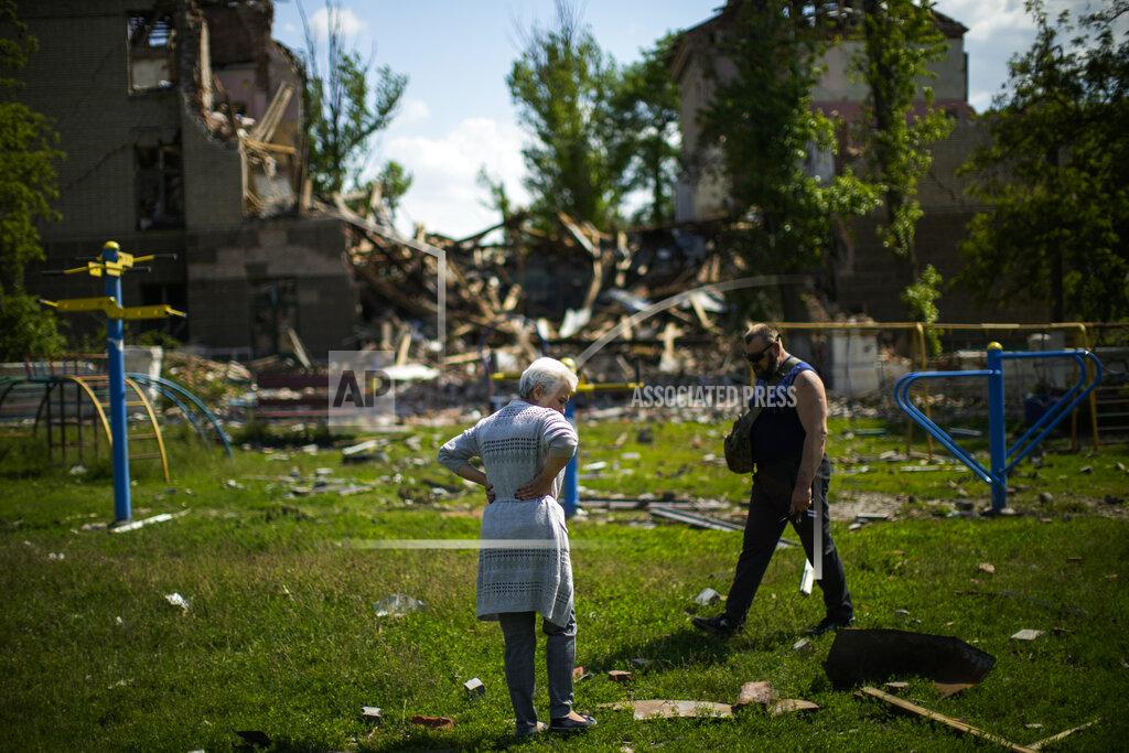 Francisco Seco Local residents stand next to a school destroyed in a Russian bombing in Bakhmut, eastern Ukraine, Tuesday, May 24, 2022. The town of Bakhmut has been coming under increasing artillery strikes, particularly over the last week, as Russian forces try to press forward to encircle the city of Sieverodonetsk to the northeast. (AP Photo/Francisco Seco)