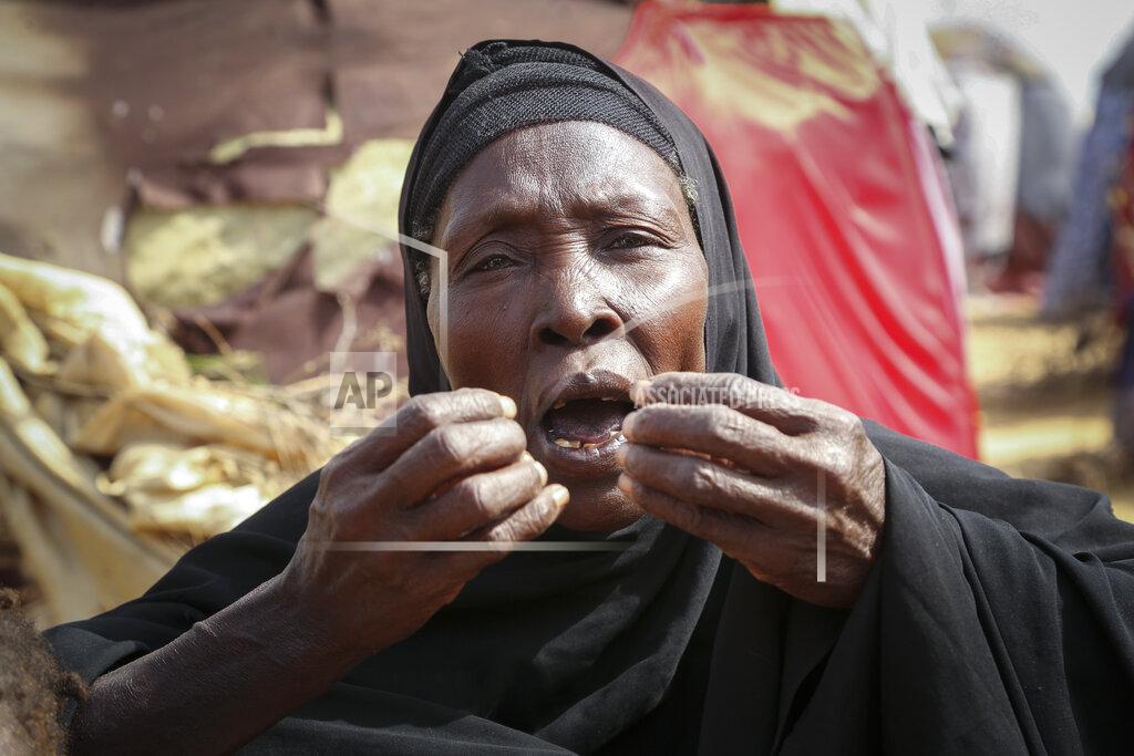 Farah Abdi Warsameh Dhahabo Isse, 60, describes how she fled from the drought without food or water causing four of her children to die of hunger, outside her makeshift tent at a camp for the displaced on the outskirts of Mogadishu, Somalia Thursday, June 30, 2022. The war in Ukraine has abruptly drawn millions of dollars away from longer-running humanitarian crises and Somalia is perhaps the most vulnerable as thousands die of hunger amid the driest drought in decades. (AP Photo/Farah Abdi Warsameh)