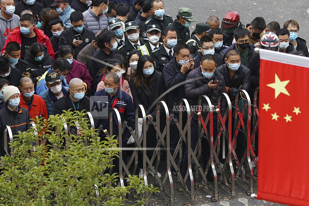 Uncredited Airport workers wearing face masks to help curb the spread of the coronavirus wait for COVID-19 testing at the Shanghai Pudong International Airport in Shanghai, Monday, Nov. 23, 2020. Chinese authorities are testing millions of people, imposing lockdowns and shutting down schools after multiple locally transmitted coronavirus cases were discovered in three cities across the country last week. (AP Photo)