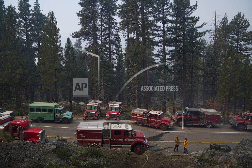 Jae C. Hong Fire trucks are parked along Highway 89 as fire crews build a fire line to keep the Caldor Fire from spreading in South Lake Tahoe, Calif., Friday, Sept. 3, 2021. Fire crews took advantage of decreasing winds to battle a California wildfire near popular Lake Tahoe and were even able to allow some people back to their homes but dry weather and a weekend warming trend meant the battle was far from over. (AP Photo/Jae C. Hong)