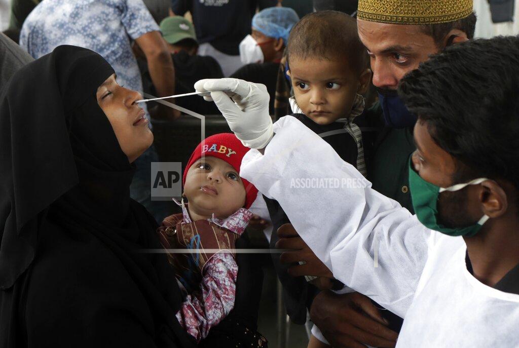 Rajanish Kakade A health worker collects a swab sample for COVID-19 test at a train station in Mumbai, India, Thursday, July 22, 2021. (AP Photo/Rajanish Kakade)