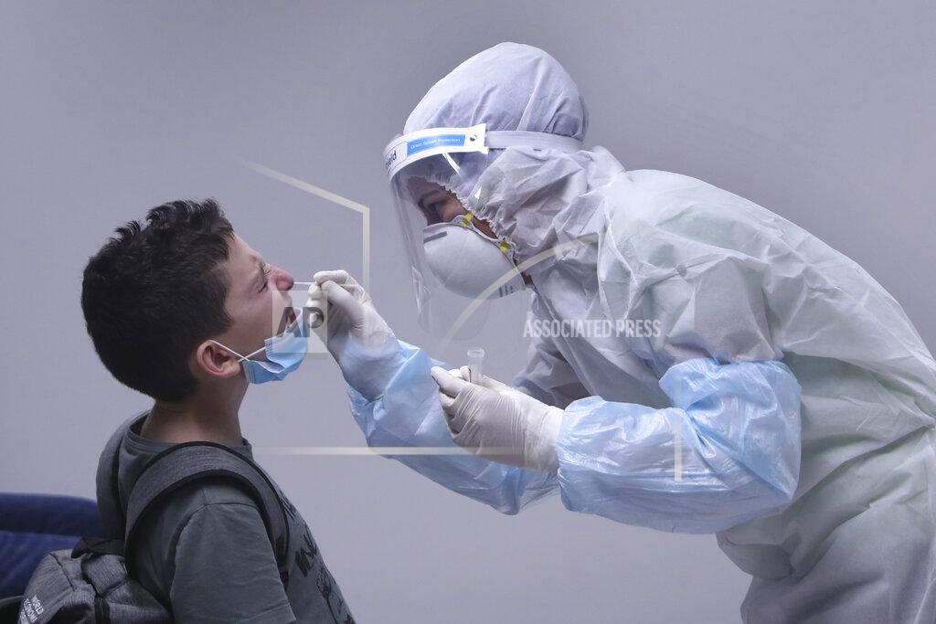 Bilal Hussein A healthcare worker takes a swab sample from a passenger who arrived at the Rafik Hariri International Airport in Beirut, Lebanon, Wednesday, July 1, 2020. Beirut's airport is partially reopening after a three-month shutdown and Lebanon's cash-strapped government is hoping that thousands of Lebanese expatriates will return for the summer, injecting dollars into the country's sinking economy. (AP Photo/Bilal Hussein)