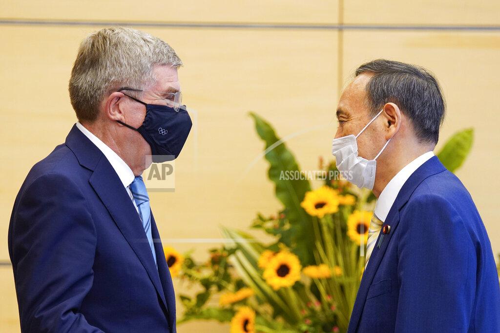 International Olympic Committee President Thomas Bach, left, meets Japanese Prime Minister Yoshihide Suga during his courtesy call at the latter's official residence in Tokyo Wednesday, July 14, 2021. (Kimimasa Mayama/Pool Photo via AP)