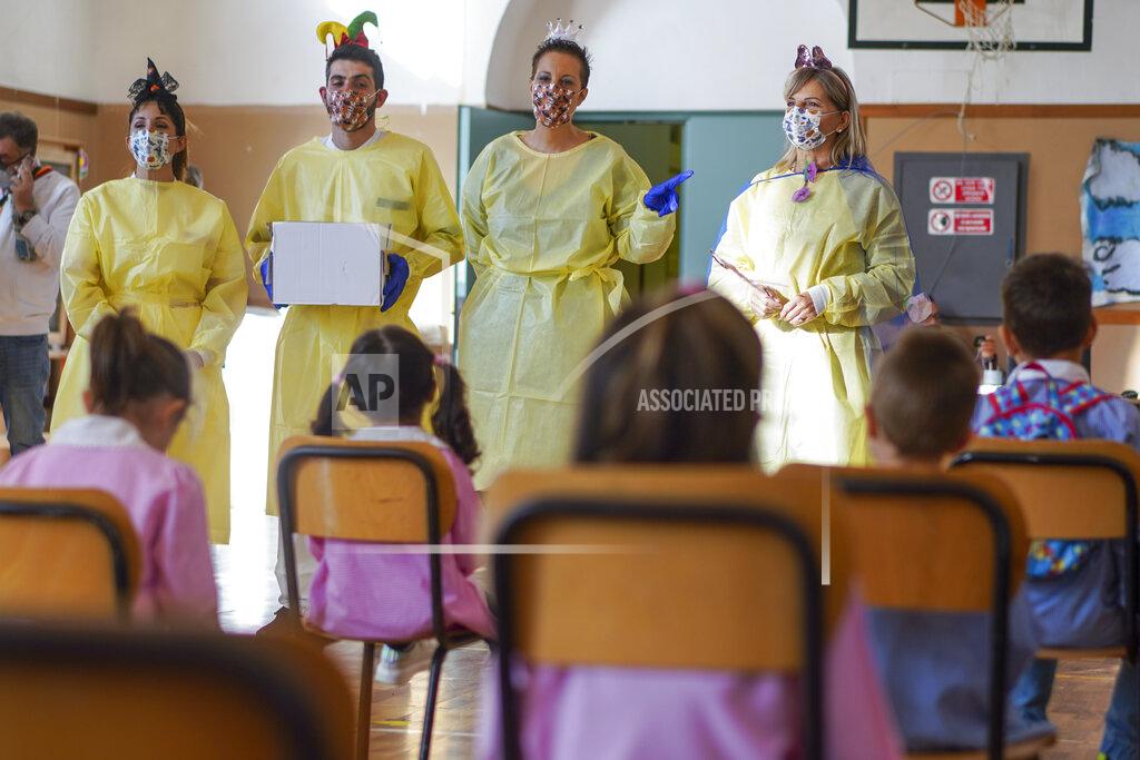 Andrew Medichini Medical personnel talk to children as they prepare them to receive non-invasive Covid 19 tests with chewing gum at the G.B. Grassi school, in Fiumicino, near Rome, Tuesday, Oct. 6, 2020. (AP Photo/Andrew Medichini)