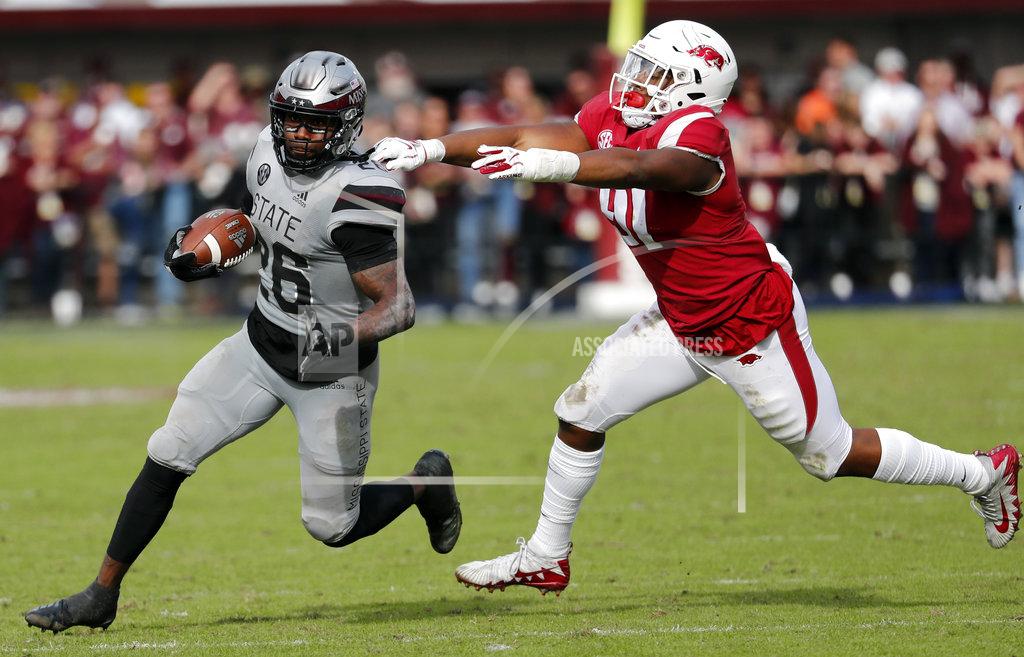 Rogelio V. Solis Arkansas quarterback Ty Storey (4) fumbles the ball after being double teamed by Arkansas defensive back Jayden Minchew (38) and defensive lineman Randy Ramsey (10) during the first half of an NCAA college football game in Starkville, Miss., Saturday, Nov. 17, 2018. Mississippi State won 52-6. (AP Photo/Rogelio V. Solis)