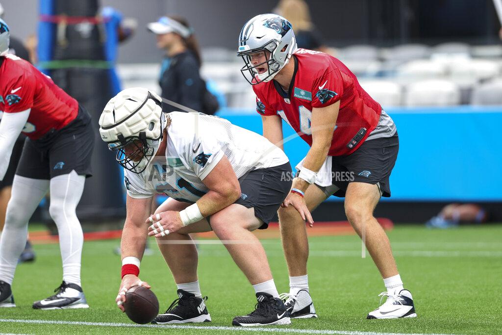 Carolina Panthers quarterback Sam Darnold, right, takes the snap from center Matt Paradis during a Fan Fest practice at the NFL football team's training camp in Charlotte, N.C., Friday, Aug. 6, 2021. (AP Photo/Nell Redmond)