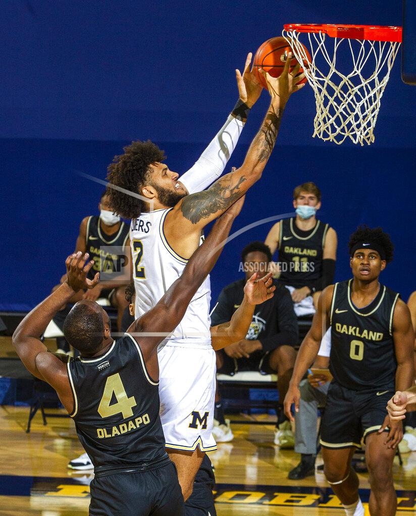 Tony Ding Michigan forward Isaiah Livers (2) goes to the basket while defended by Oakland forward Daniel Oladapo (4) in the first half of an NCAA college basketball game at Crisler Center in Ann Arbor, Mich., Sunday, Nov. 29, 2020. (AP Photo/Tony Ding)