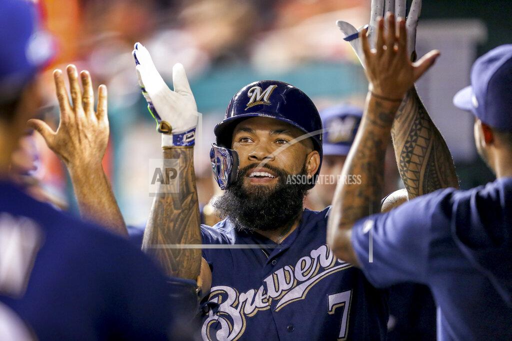 Andrew Harnik FILE - In this Oct. 1, 2019, file photo, Milwaukee Brewers' Eric Thames high fives teammates after hitting a solo home run during the second inning of a National League wild card baseball game against the Washington Nationals at Nationals Park in Washington. (AP Photo/Andrew Harnik, File)