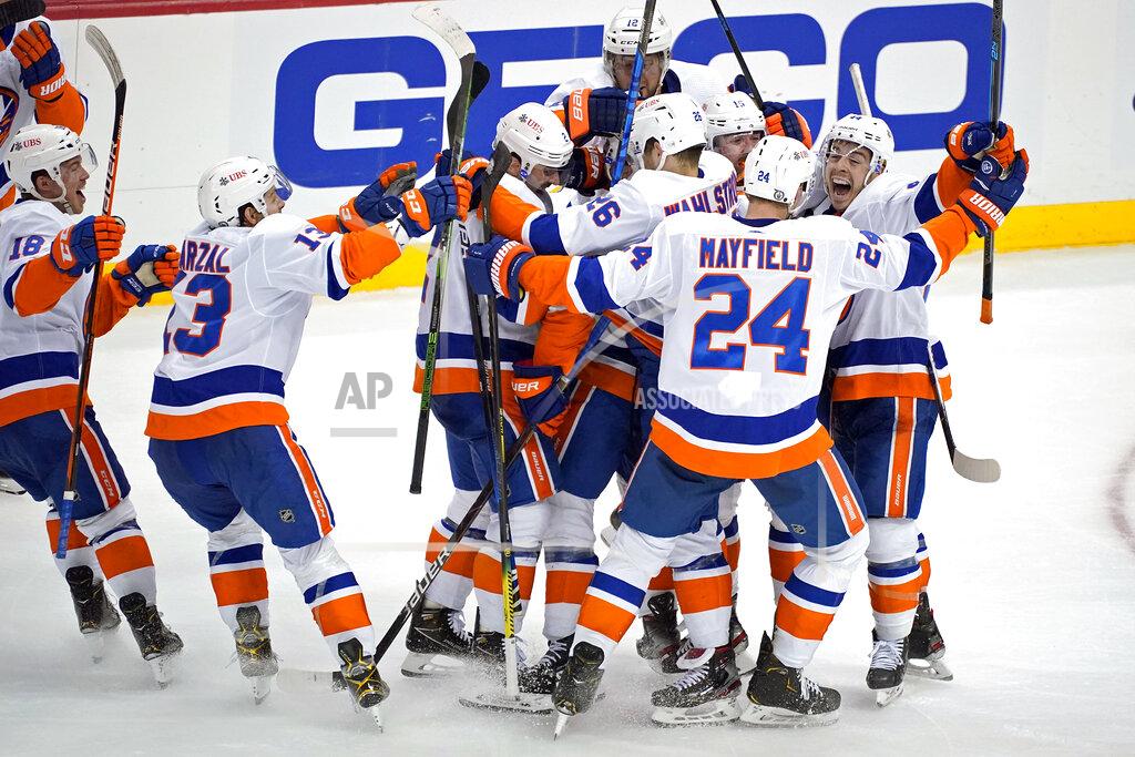 Gene J. Puskar The New York Islanders celebrate a winning overtime goal by Kyle Palmieri in Game 1 of an NHL hockey Stanley Cup first-round playoff series against the Pittsburgh Penguins in Pittsburgh, Sunday, May 16, 2021. (AP Photo/Gene J. Puskar)