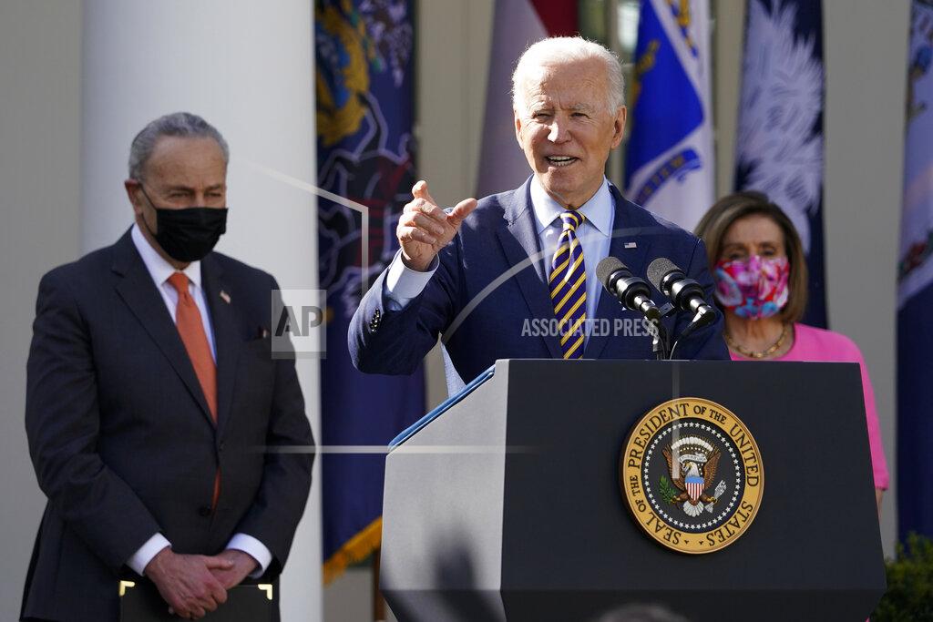Alex Brandon President Joe Biden speaks about the American Rescue Plan, a coronavirus relief package, in the Rose Garden of the White House, Friday, March 12, 2021, in Washington. Senate Majority Leader Chuck Schumer of N.Y., left, and House Speaker Nancy Pelosi of Calif., listen. (AP Photo/Alex Brandon)