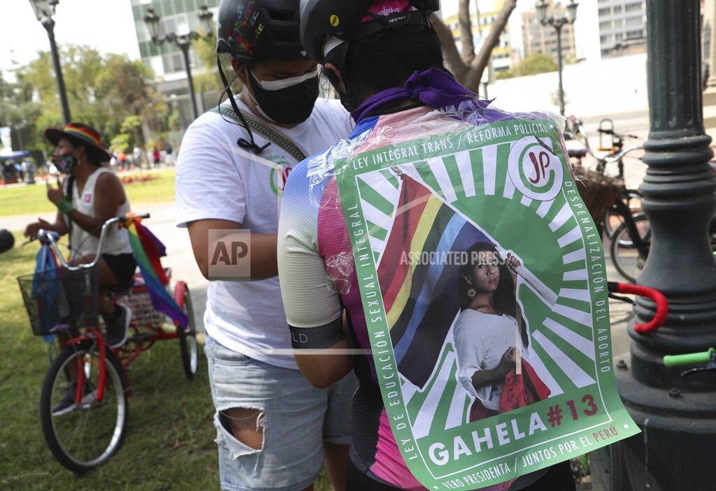Martin Mejia Supporters of Together for Peru party transgender congressional candidate Gahela Cari canvas for votes as she campaigns, pictured in the background on left, in Lima, Peru, Sunday, March 28, 2021. If elected, Cari will become the first trans representative in the Peruvian Congress. (AP Photo/Martin Mejia)