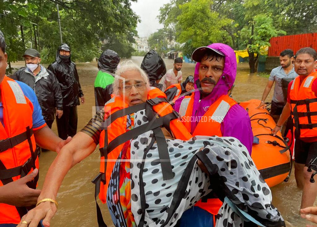 Uncredited A National Disaster Response Force personnel rescues an elderly woman stranded in floodwaters in Kolhapur, in the western Indian state of Maharashtra, Friday, July 23, 2021. Landslides triggered by heavy monsoon rains hit parts of western India, killing at least 32 people and leading to the overnight rescue of more than 1,000 other people trapped by floodwaters, officials said Friday. (AP Photo)